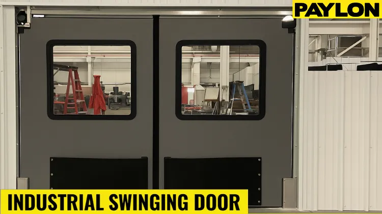 Gray industrial swinging doors with vision panels installed in a warehouse Gray industrial swinging doors with vision panels installed in a warehouse