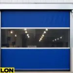 High-speed roll-up door with blue vinyl panels and clear vision strip, installed on a corrugated metal industrial building exterior