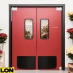 Industrial Door PE-8000 in a florist shop, with bright red panels and viewing windows, surrounded by colorful rose arrangements in metal buckets on both sides