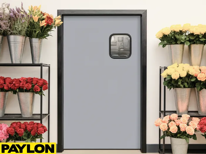 Retail Door PE-710 in a florist shop, featuring a sleek gray design with a small window Retail Door PE-710 in a florist shop, featuring a sleek gray design with a small window, framed by vibrant flower arrangements in metal buckets on black shelving units