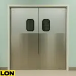 Retail Door PE-620ALC double-swing doors installed in a veterinary clinic setting, featuring stainless steel lower panels, tinted oval windows, and a clean mint-green interior with cabinets and a framed dog portrait