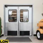 Retail Door PE-620ALC in a tool rental shop, showcasing a double-action swinging door with clear windows and a sturdy stainless steel frame, placed in an industrial setting