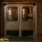 Retail Door PE-620ALC swinging doors inside a microbrewery, separating the taproom with barrels from the production area with stainless steel brewing tanks.