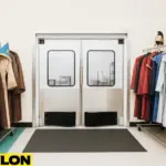 Retail Door PE-620ALC swinging doors installed in a costume shop backroom, surrounded by colorful cosplay and theatrical outfits on rack