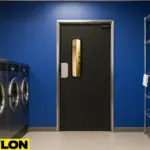 Retail Door PE-710 installed in a commercial laundromat, set against a bright blue wall beside chrome shelving and industrial washers, ideal for separating staff-only areas while keeping workflow efficient and discreet