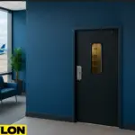 Retail Door PE-710 installed in an airport lounge staff access area, with a blue ‘Airport Lounges Staff Access Only’ sign above, modern blue lounge chairs on the left, a potted plant by the window, and airplanes visible on the tarmac outside