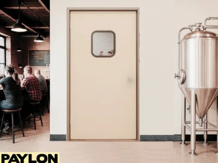 Retail Door PE-710 swinging door inside a microbrewery, separating the stainless steel brewing tanks in the production areas Retail Door PE-710 swinging door inside a microbrewery, separating the stainless steel brewing tanks in the production area from the rustic taproom where customers are seated at the bar.
