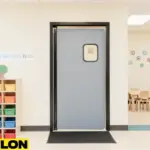 Retail Door PE-710 swinging door installed in a colorful preschool classroom, safely dividing spaces with cubbies, learning decor, and child-sized tables