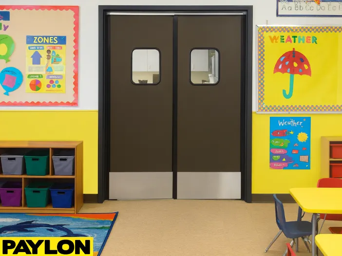 Retail Door PE-720 double swinging doors installed in a colorful preschool classroom, providing safe room division with cubbies, posters, and child-sized tables and chairs Retail Door PE-720 double swinging doors installed in a colorful preschool classroom, providing safe room division with cubbies, posters, and child-sized tables and chairs