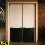 Retail Door PE-720 swinging door in a microbrewery, dividing the stainless steel brewing tanks in the production area from the rustic taproom with brick walls, wooden chairs, and patrons enjoying craft beer
