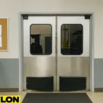 Retail Door PE-620ALC swinging doors installed in a waste management facility, showing the transition between office space and the warehouse floor