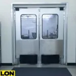 A double swinging door with large windows and stainless steel kick plates providing a view into a grocery store stockroom