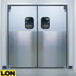 A pair of closed aluminum double swinging doors with a stainless steel finish in a clean hospital hallway.