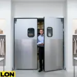 A retail employee walks through a set of aluminum double swinging doors leading from the sales floor to a stockroom