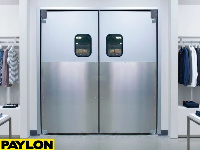 Aluminum double swinging doors in modern retail clothing store with sleek metal finish and vision panel