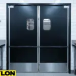 Black PE-Series Swinging Kitchen Doors with vision panels installed in a commercial restaurant kitchen
