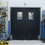 Black double swinging doors with windows in an industrial or retail stockroom with tools and tires on shelves Black double swinging doors with windows in an industrial or retail stockroom with tools and tires on shelves