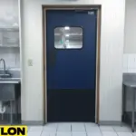Blue single swinging door with window in a commercial kitchen featuring stainless-steel sink and counter Blue single swinging door with window in a commercial kitchen featuring stainless-steel sink and counters