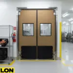 Brown double swinging doors with vision panels in a food processing area, built for hygiene and temperature control