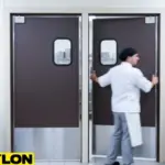 Chef opening brown PE-Series kitchen swinging traffic doors with windows in a busy kitchen