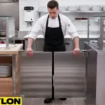 Chef opening stainless steel restaurant swinging door in commercial kitchen Chef opening stainless steel restaurant swinging door in commercial kitchen