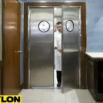 Chef walking through stainless steel restaurant double doors with round windows, built for safety, durability, and professional kitchen use