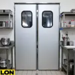 Closed silver PE-Series kitchen swinging traffic doors with vision panels in a prep area