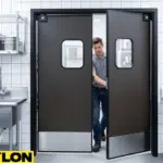 Employee walking through dark brown industrial swinging doors in a commercial kitchen Employee walking through dark brown industrial swinging doors in a commercial kitchen