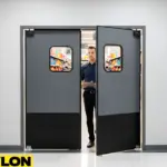 Gray double-acting swinging doors by Paylon separating a grocery stockroom from sales floor, built with reinforced panels and clear windows for visibility and safety