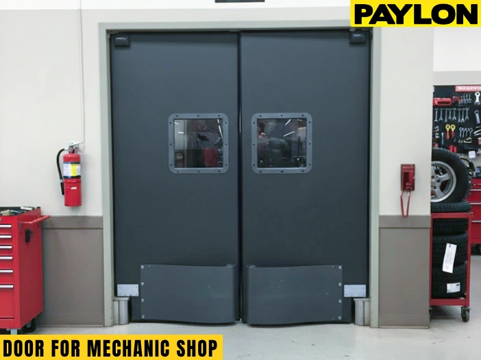 Gray double swinging doors with vision panels inside a mechanic shop, framed by red tool chests and workshop equipments Gray double swinging doors with vision panels inside a mechanic shop, framed by red tool chests and workshop equipment