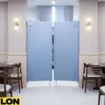 Gray restaurant café doors separating dining area and kitchen, maintaining workflow and safety Gray restaurant café doors separating dining area and kitchen, maintaining workflow and safety