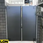 Gray restaurant swinging doors with professional kitchen background and clear floor space Gray restaurant swinging doors with professional kitchen background and clear floor space