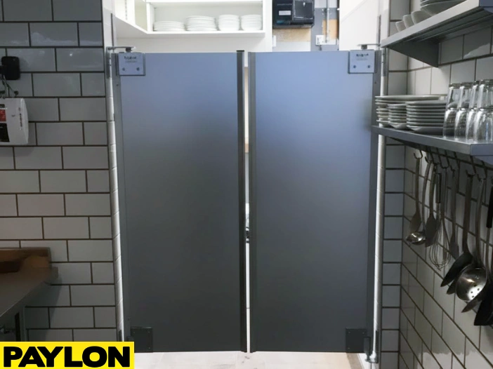 Gray restaurant swinging doors with professional kitchen background and clear floor spaces Gray restaurant swinging doors with professional kitchen background and clear floor space