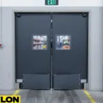 Grey double-swing warehouse impact door with vision panels in high-traffic industrial area Grey double-swing warehouse impact door with vision panels in high-traffic industrial area