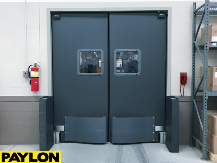 Heavy-duty gray industrial swinging doors with bumpers in a warehouse environment Heavy-duty gray industrial swinging doors with bumpers in a warehouse environment