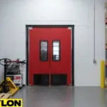 Heavy-duty red swinging doors installed in a warehouse storage zone example of how to choose the right door for your backroom, breakroom, or prep area