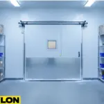 Insulated swinging freezer door with impact-resistant lower panel in a high-traffic storage area