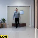 Man walking through beige swinging doors for a lounge, designed for smooth two-way traffic and quiet operation