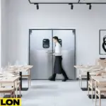 Paylon aluminum swinging doors in a modern restaurant dining area with server carrying plates