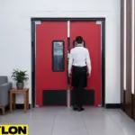 Red PE-series swinging doors for a lounge, featuring kick plates and vision panels for safe, stylish staff access