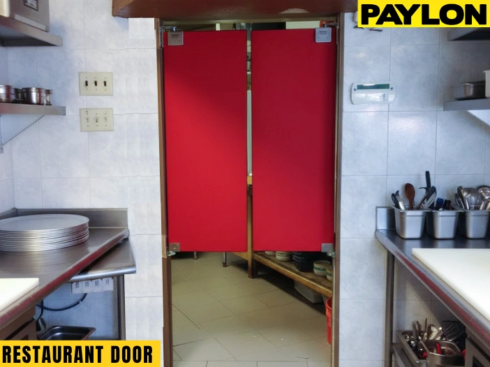 Red café-style swinging door in a commercial kitchen with stainless steel counters and shelve Red café-style swinging door in a commercial kitchen with stainless steel counters and shelves