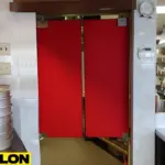 Red double-action swinging kitchen door separating prep and cooking areas Red double-action swinging kitchen door separating prep and cooking areas