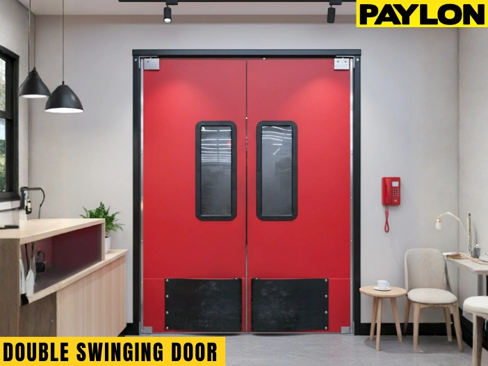 Red double swinging doors with black kick plates in modern café or office interior with seating area