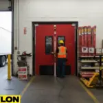 Red impact-resistant swinging doors in warehouse loading dock entry