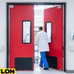 Red impact swinging doors opening as a staff member passes through with a cart