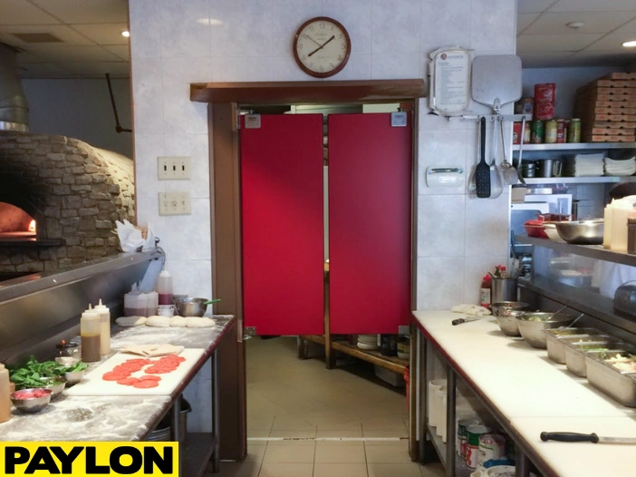 Red pizza parlor swinging doors in a compact restaurant kitchen separating prep and cooking areas Red pizza parlor swinging doors in a compact restaurant kitchen separating prep and cooking areas