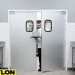 Restaurant employee walking through aluminum-clad swinging kitchen doors with vision panels in a clean commercial kitchen