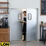 Server carrying drinks through PE-510ALC aluminum swinging doors in a café for efficient service flow