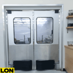 Stainless steel double swinging doors in a café prep area with shelves and coffee equipments