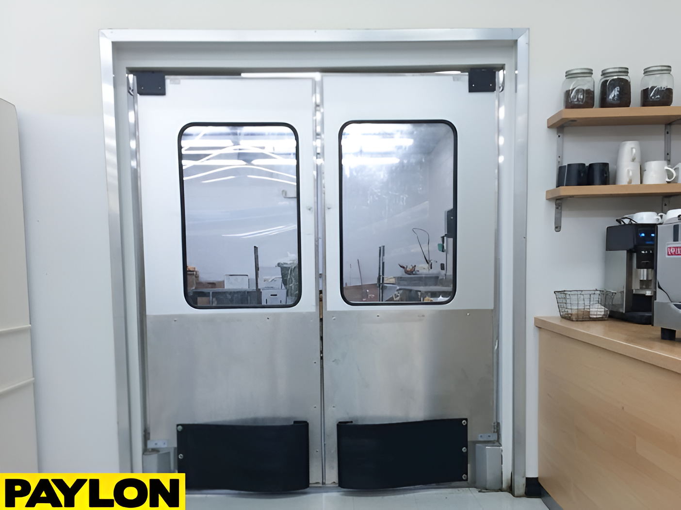 Stainless steel double swinging doors in a café prep area with shelves and coffee equipments